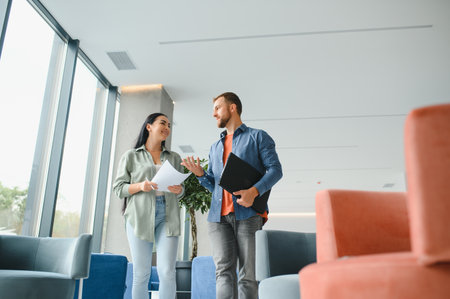 Two business coworkers walking through a lobby of an office building.