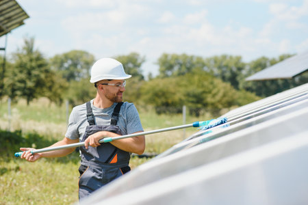 young worker cleaning solar panels