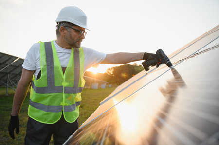 Portrait of smiling confident engineer technician with electrical screwdriver, standing in front of...