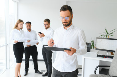 Business people stand on the background of the office corridor.の写真素材