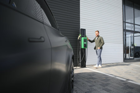 a man charges an electric car.の写真素材