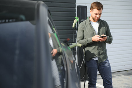 Man charging electric car by the house.