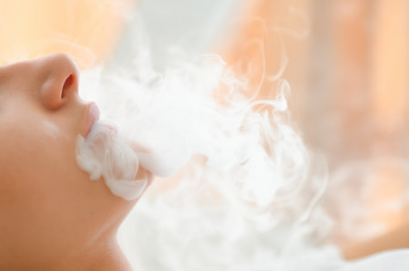 A woman smokes an electronic cigarette.の写真素材