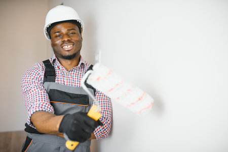 African-American decorator painting light wall.の写真素材