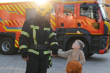 Portrait of a fireman and a little boy with a teddy bearの写真素材