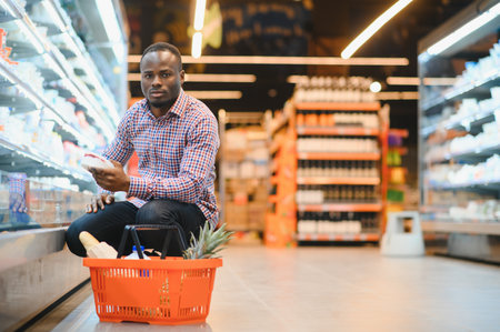 Young African man buying in grocery section at supermarket.の写真素材