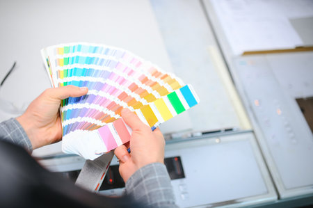Typographer standing with color swatches at the printing manufacturing.