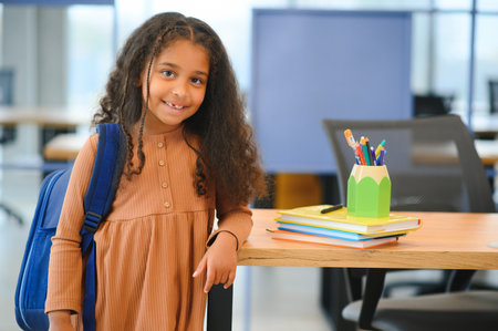 African-American girl in school looking at camera while standing in classroom, copy space.の写真素材