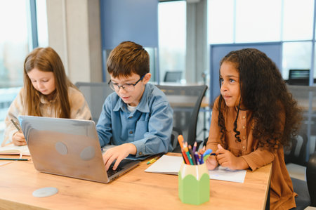 schoolchildren for a laptop at school.の写真素材