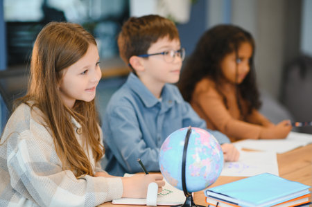 students to schoolwork during lesson in light classroom at school.の写真素材