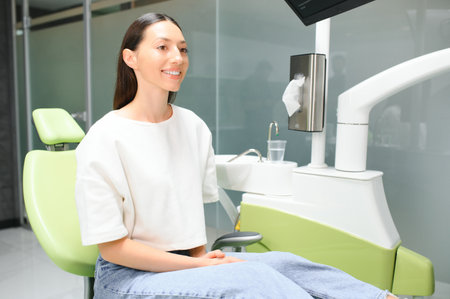 Smiling and satisfied patient in a dental office after treatment.の写真素材