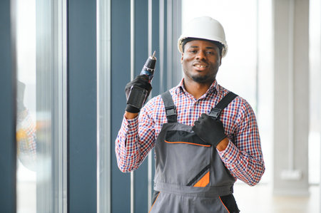 Construction worker repairing plastic window with screwdriver indoors, space for text. Banner design