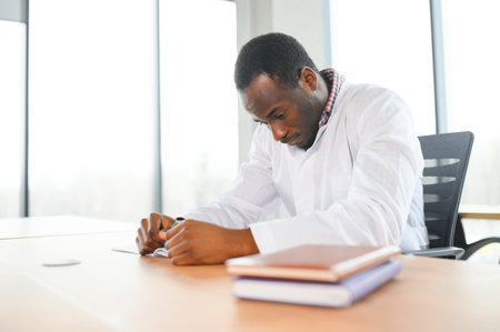 Tired african male therapist sitting in his office.の写真素材