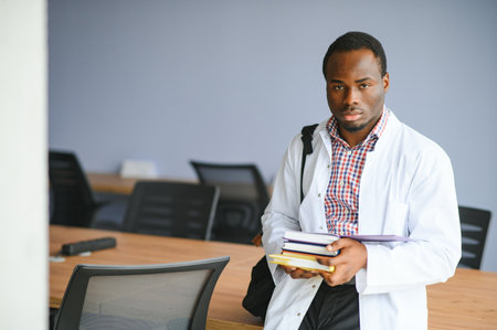 Black male doctor student wearing a lab coat with book.の写真素材