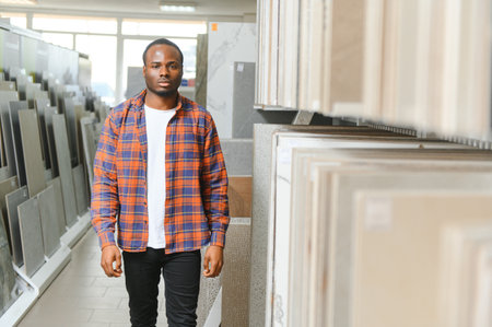 African american man customer choosing ceramic tile at building materials store.の写真素材