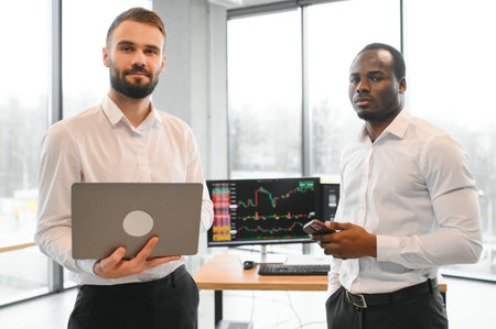 Two diverse crypto traders brokers stock exchange market investors discussing trading charts research reports growth using pc computer looking at screen analyzing invest strategy, financial risks.の写真素材