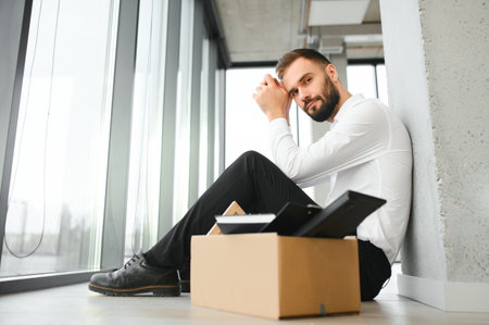 Sad fired businessman sitting outside meeting room after being dismissed.の写真素材