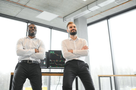 Two diverse crypto traders brokers stock exchange market investors discussing trading charts research reports growth using pc computer looking at screen analyzing invest strategy, financial risks.の写真素材