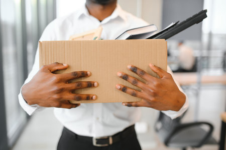 Portrait of african american employee being fired closing laptop with business data while holding...