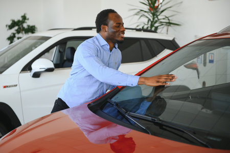 Handsome African man choosing a new car at the dealership.の写真素材