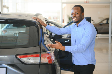 Handsome man is standing near his new car and smiling.の写真素材