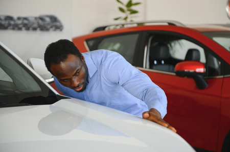 Handsome man is standing near his new car and smiling.の写真素材