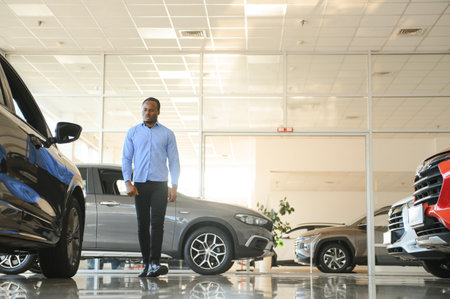 Handsome African man choosing a new car at the dealership.の写真素材