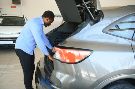 Handsome African man choosing a new car at the dealership.の写真素材