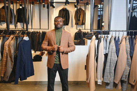 Handsome young African man wearing suit in shop.の写真素材