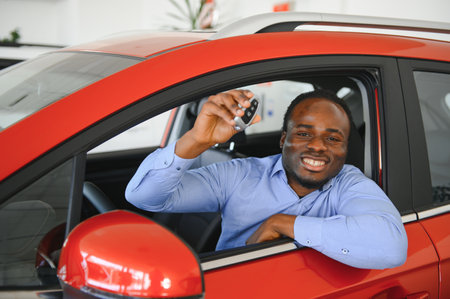 Happy Car Buyer, New Car Owner Concept. Portrait Of Excited Young African American Guy In Dealership Showroom.の写真素材