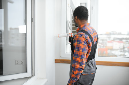African service man installing window.