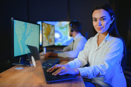 Friendly smiling woman call center operator with headset using computer at office.の写真素材