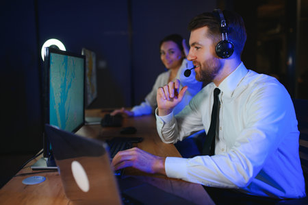 Center of dispatching maintenance. Portrait of cheerful woman and man working via headset microphone...