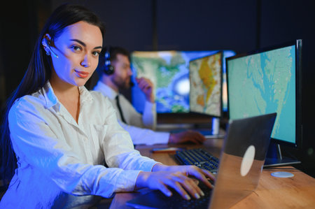 Friendly smiling woman call center operator with headset using computer at office.