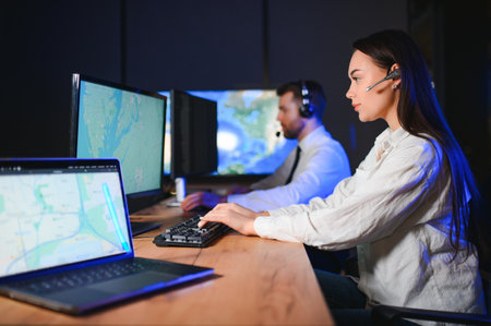 Center of dispatching maintenance. Portrait of cheerful woman and man working via headset microphone while sitting on navigation controller board.の写真素材