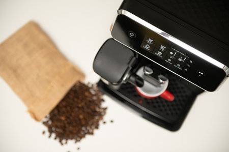 Modern espresso coffee machine with a cup in interior of kitchen closeup.