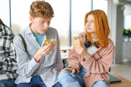 Friendly students having snack at break.の写真素材