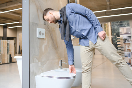 Male customer looking at toilets on sale at a modern store or shopping center.