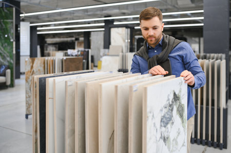 man choosing ceramic tiles and utensils for his home bathroom.の写真素材