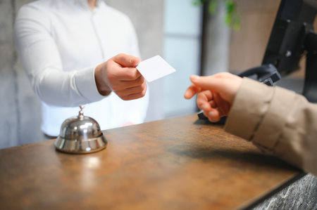 Close up of hand guest takes room key at check-in desk of the hotel.Hotel concept.の写真素材