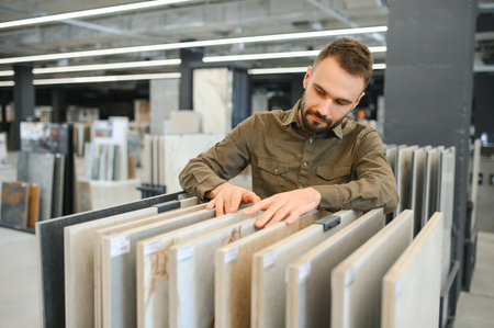 Man choosing tile among different samples in store.
