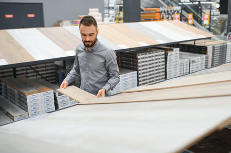 man choosing laminate samples in hardware store.