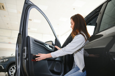 Happy friendly woman customer female buyer client chooses auto wants to buy new automobile in showroom vehicle salon dealership store motor show indoorの写真素材