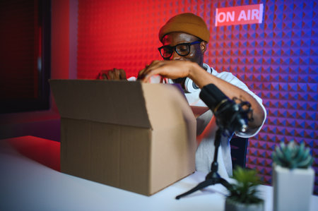 Fashion blog. Blogger unpacking box with new trendy clothes in front of professional camera