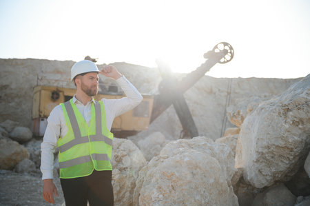 Worker in hardhat standing in stone quarry.の写真素材