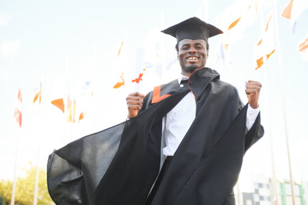 Happy graduate. Happy African man in graduation gowns.の写真素材