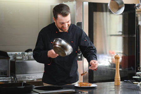 Closeup of a concentrated male chef garnishing food in the kitchen.