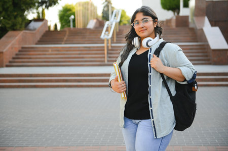 Portrait of Indian girl student with books near university.