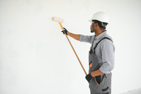 painter man painting the wall, with paint roller.の写真素材