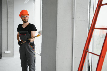 Male workers doing interior renovation in apartment. Portrait of happy smiling confident adult man...